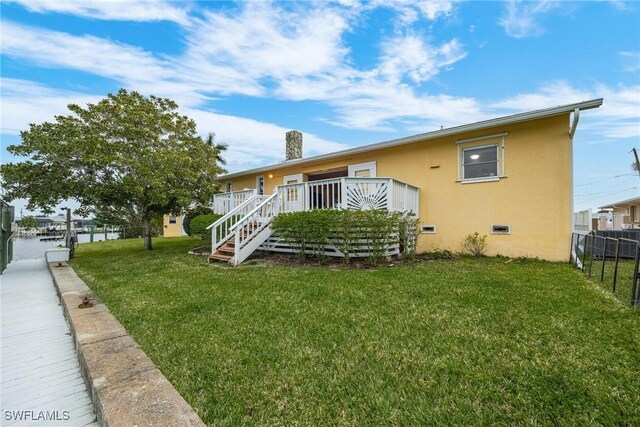 view of front of property with a front yard and a deck