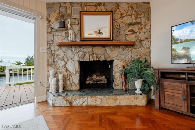 interior space with a stone fireplace and parquet flooring