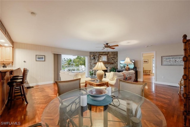 living room featuring dark parquet flooring and ceiling fan