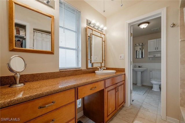 bathroom with vanity, tile patterned flooring, and toilet