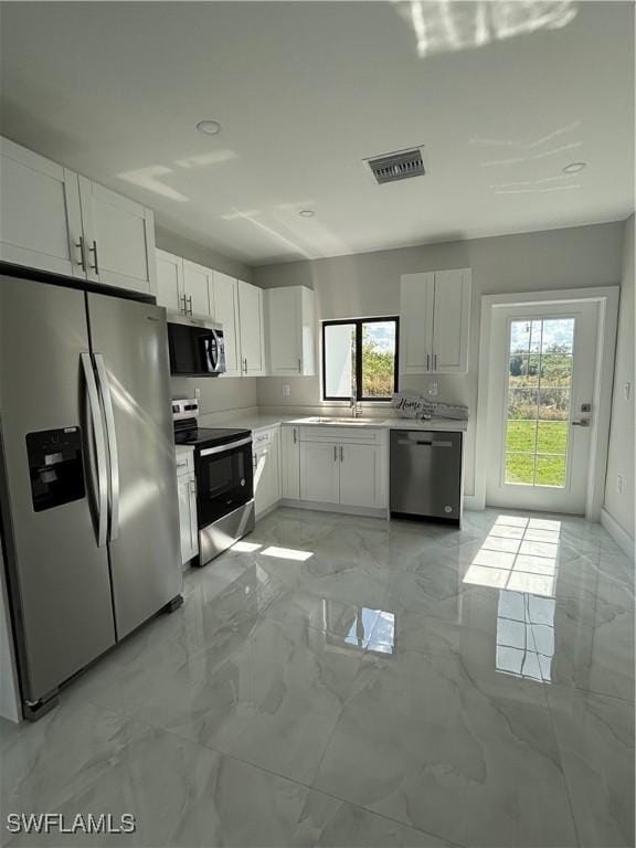 kitchen featuring white cabinetry, a healthy amount of sunlight, stainless steel appliances, and sink