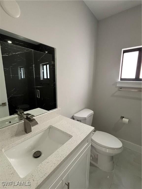 bathroom with a shower with door, vanity, and toilet