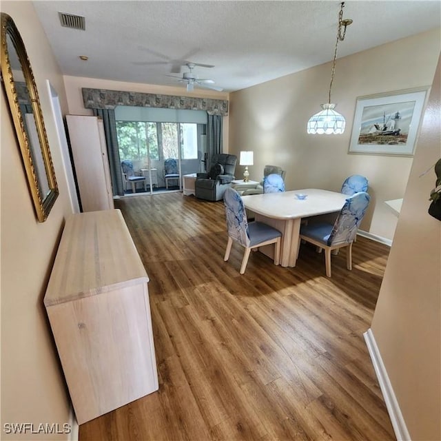 dining space featuring ceiling fan, a textured ceiling, and wood-type flooring