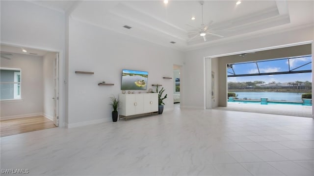 unfurnished living room featuring crown molding, a raised ceiling, ceiling fan, and a towering ceiling