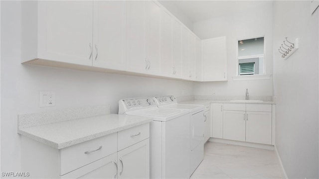 laundry area featuring cabinets, washing machine and dryer, and sink