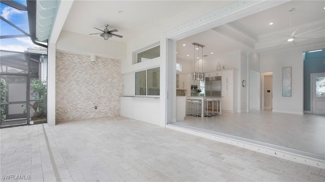 view of patio / terrace featuring ceiling fan and glass enclosure