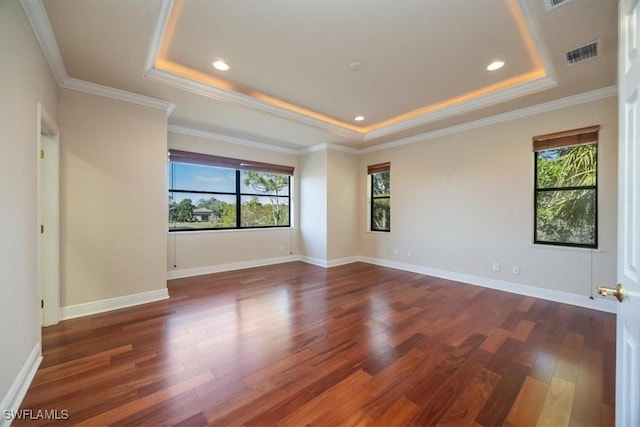 unfurnished room featuring crown molding, dark hardwood / wood-style floors, and a raised ceiling