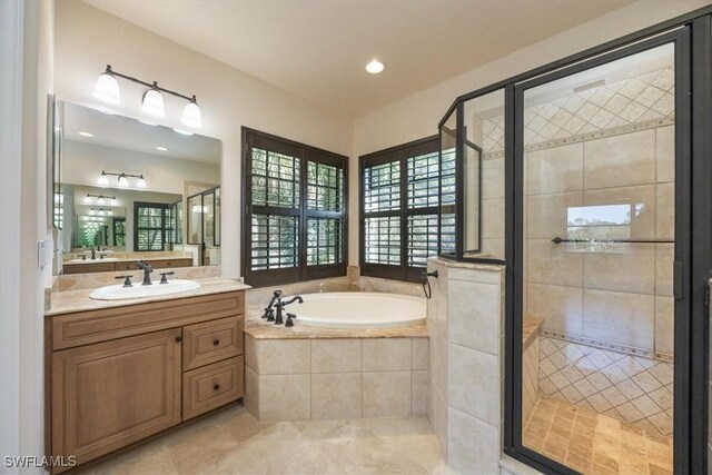 bathroom with vanity and separate shower and tub