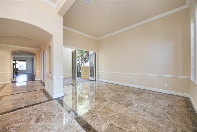 empty room with ornamental molding and a high ceiling