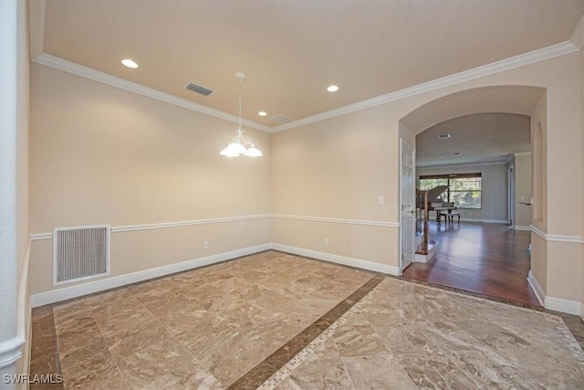 empty room featuring a notable chandelier and ornamental molding