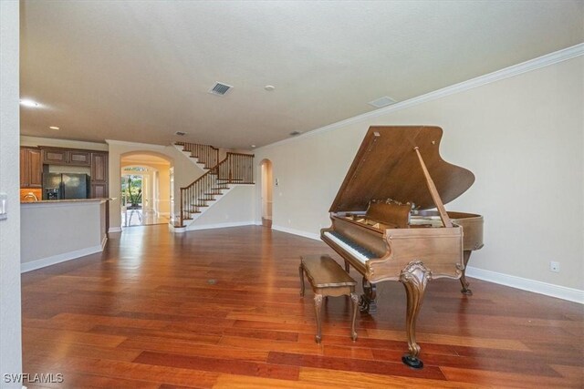 28830 Kiranicola Ct, Bonita Springs, FL 34135 - living area with arched walkways, wood finished floors, baseboards, stairway, and ornamental molding