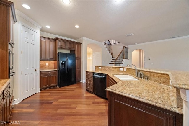 kitchen with sink, wood-type flooring, black appliances, ornamental molding, and decorative backsplash