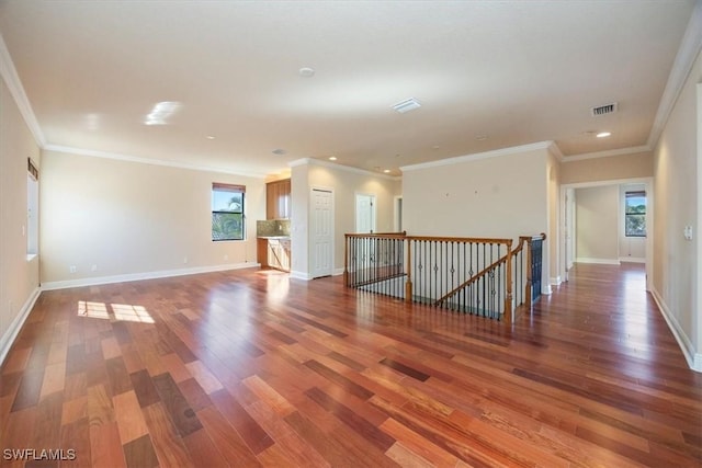 unfurnished living room featuring hardwood / wood-style flooring and ornamental molding