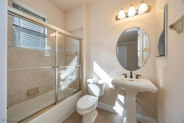 28830 Kiranicola Ct, Bonita Springs, FL 34135 - bathroom with tile patterned floors, toilet, combined bath / shower with glass door, baseboards, and a sink