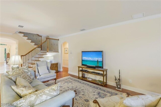 28830 Kiranicola Ct, Bonita Springs, FL 34135 - living area featuring arched walkways, ornamental molding, stairs, baseboards, and wood finished floors