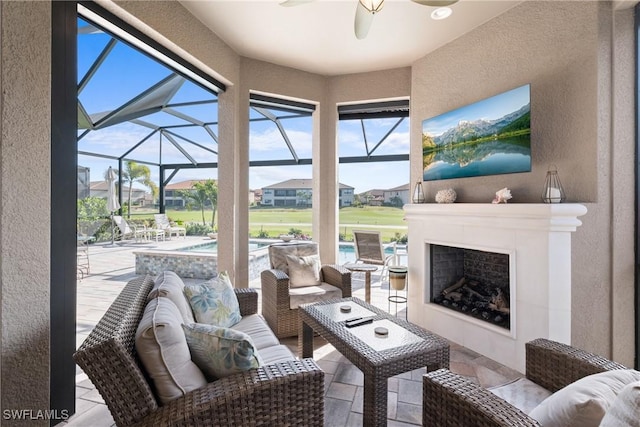 sunroom / solarium with ceiling fan and an outdoor fireplace