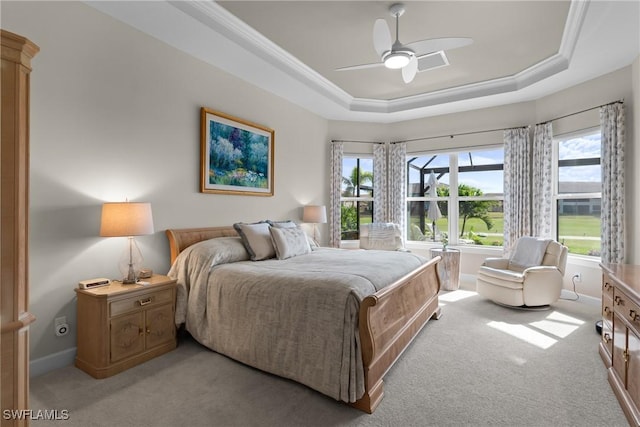 bedroom featuring light carpet, crown molding, a raised ceiling, and ceiling fan