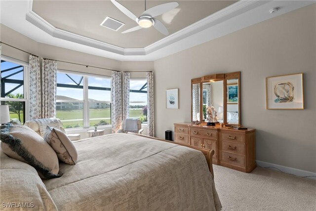 bedroom featuring light carpet, a tray ceiling, crown molding, and ceiling fan