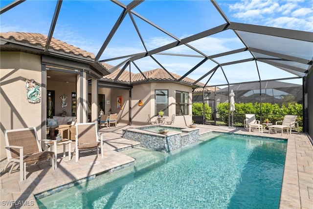 view of pool with a patio area, glass enclosure, and an in ground hot tub