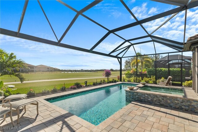 view of swimming pool with an in ground hot tub, glass enclosure, and a patio