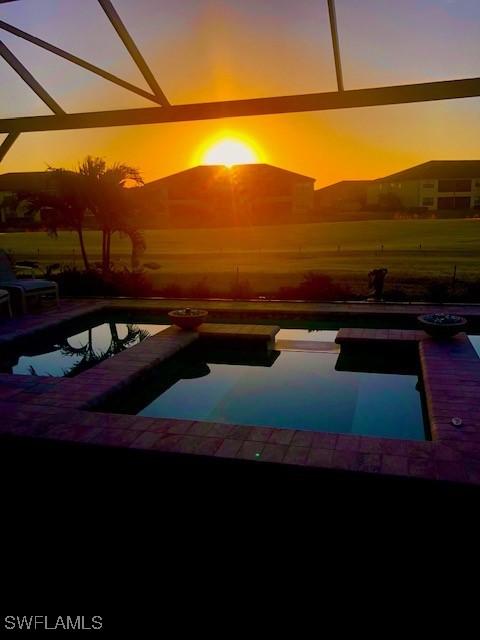 pool at dusk featuring a patio