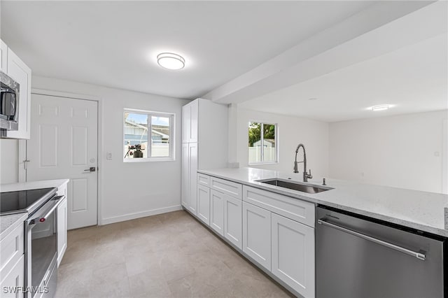 kitchen featuring sink, light stone counters, white cabinets, and appliances with stainless steel finishes