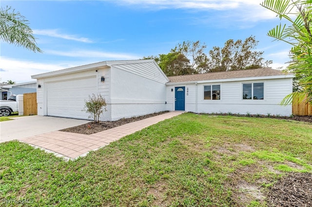 view of front of house featuring a garage, driveway, a front lawn, and stucco siding