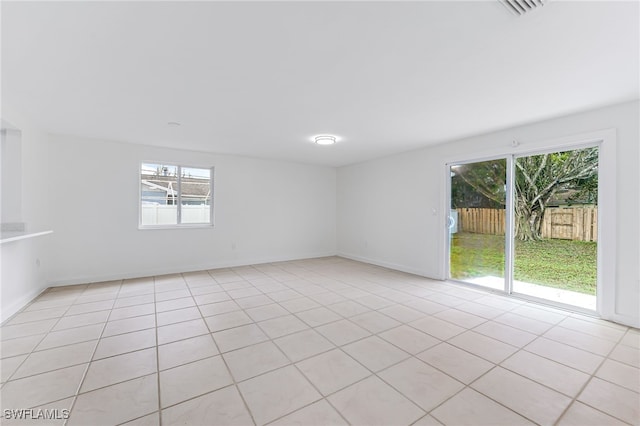 empty room with baseboards and light tile patterned floors