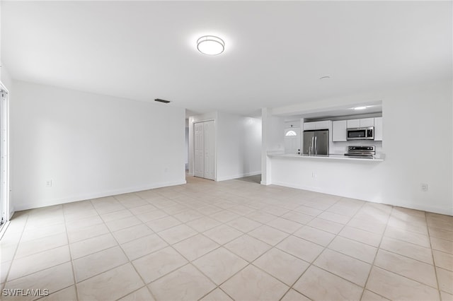 unfurnished living room with light tile patterned floors, baseboards, and visible vents