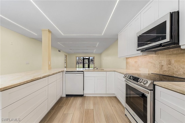 kitchen with white cabinets, kitchen peninsula, white dishwasher, and stainless steel electric stove