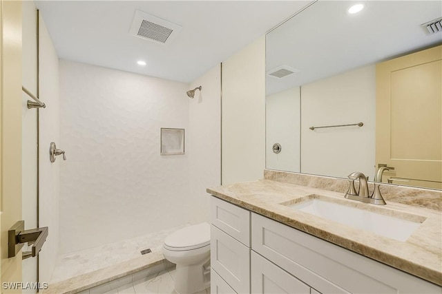 bathroom featuring vanity, toilet, a shower, and tile patterned floors