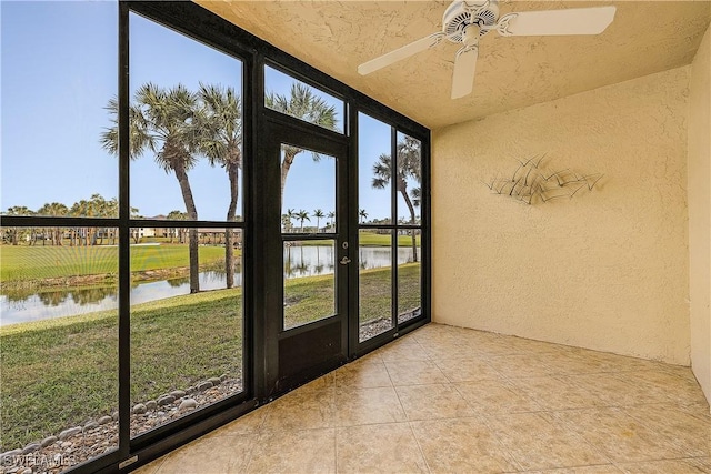 unfurnished sunroom with ceiling fan, a water view, and a wealth of natural light