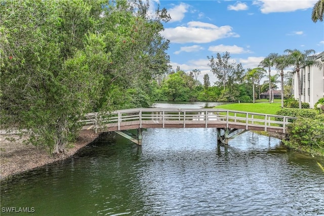 view of dock featuring a water view and a lawn