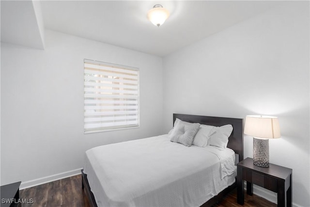 bedroom with dark hardwood / wood-style flooring