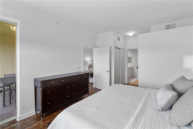 bedroom featuring a closet, connected bathroom, and dark hardwood / wood-style flooring