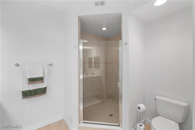 bathroom featuring tile patterned floors, toilet, and an enclosed shower