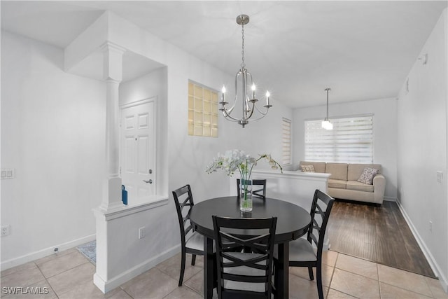 dining room with light tile patterned floors, ornate columns, and a chandelier