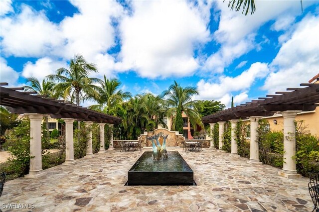 8598 Via Lungomare Cir Unit 203, Estero, FL 33928 - view of patio / terrace with a pergola and outdoor dining space