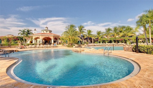 8598 Via Lungomare Cir Unit 203, Estero, FL 33928 - community pool featuring a patio area