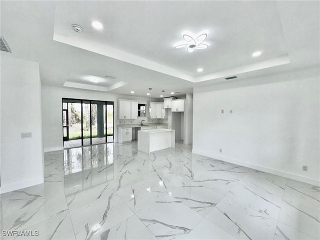 living room featuring sink and a tray ceiling