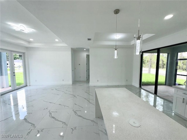 spare room with a tray ceiling and french doors