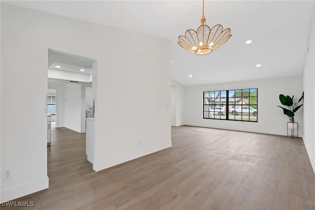 spare room featuring recessed lighting, wood finished floors, and baseboards