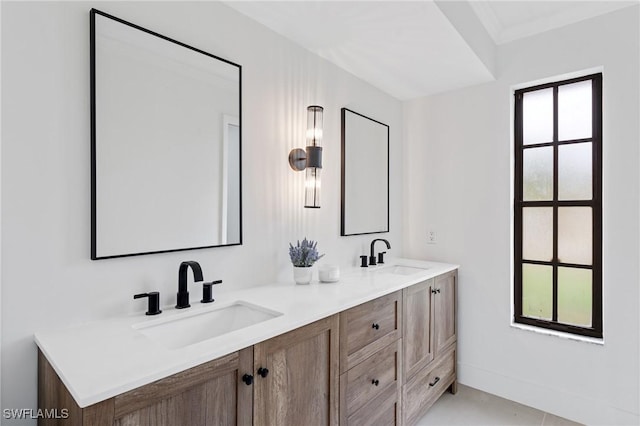 bathroom featuring ornamental molding, a sink, and double vanity