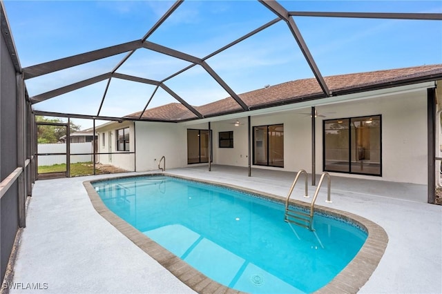 view of swimming pool featuring a fenced in pool, glass enclosure, a patio area, and a ceiling fan