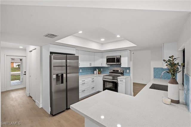 kitchen featuring appliances with stainless steel finishes, light countertops, visible vents, and white cabinetry