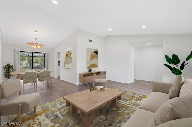 living area with baseboards, lofted ceiling, wood finished floors, an inviting chandelier, and recessed lighting