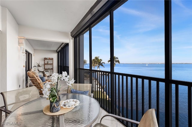 sunroom / solarium featuring a water view