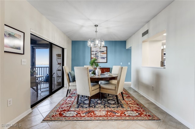 dining space featuring light tile patterned flooring and a notable chandelier