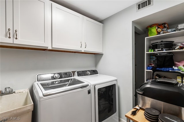 laundry area featuring washer and dryer, sink, and cabinets