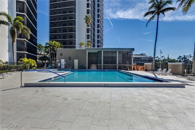 view of swimming pool with a patio and a sunroom